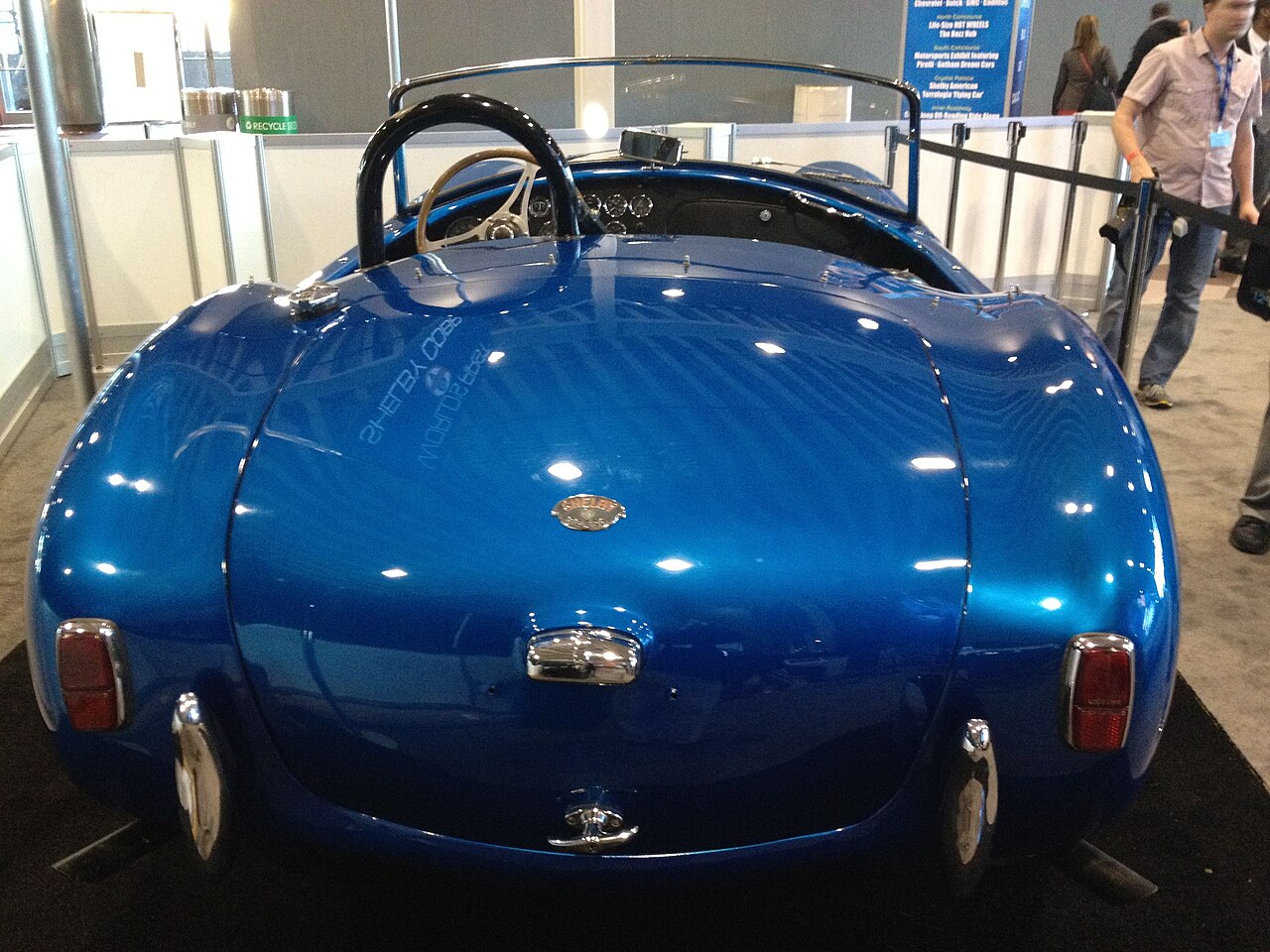 Blue Shelby Cobra CSX2000 roadster seen from directly behind at an indoor auto show.