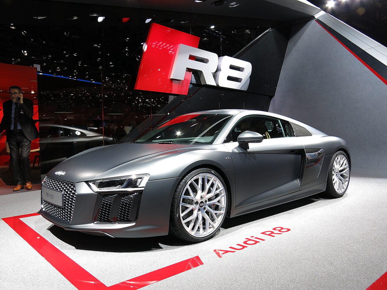 Grey Audi R8 V10 coupe, front left three-quarter view on a display stand at the 2015 Geneva Motor Show.