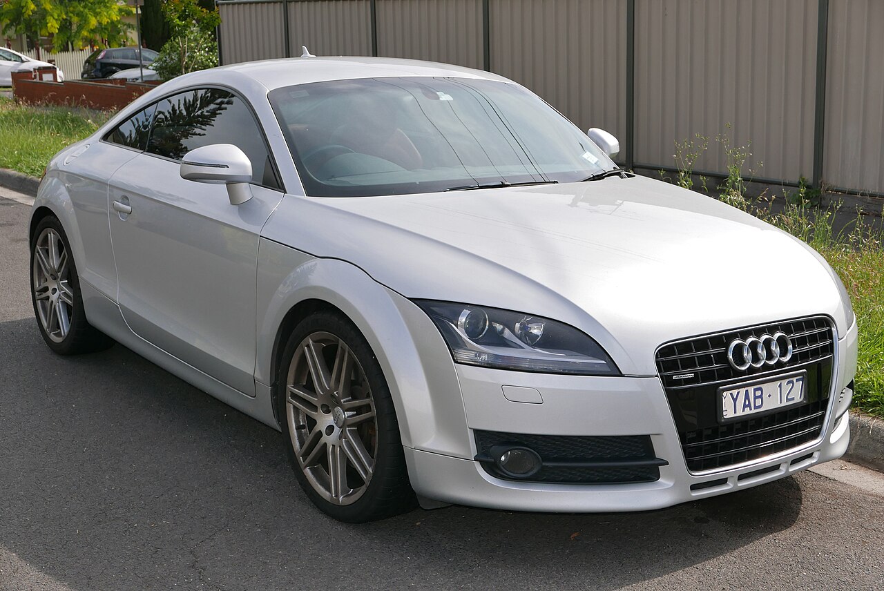 Silver 2007 Audi TT quattro coupe, front three-quarter view parked on a suburban street.