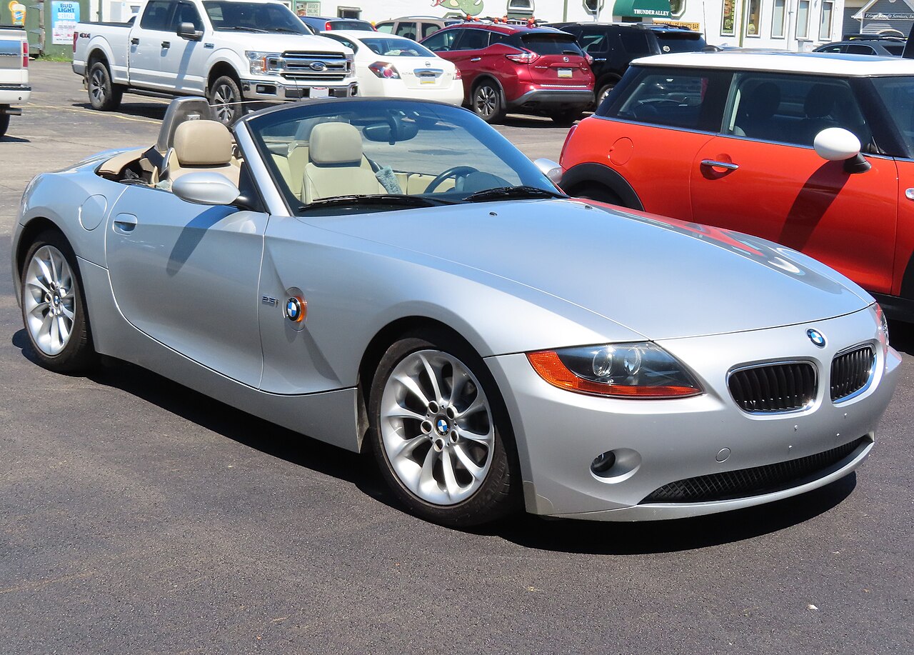 Silver 2003 BMW Z4 roadster with its roof down and tan seats, front right three-quarter view in a car park.