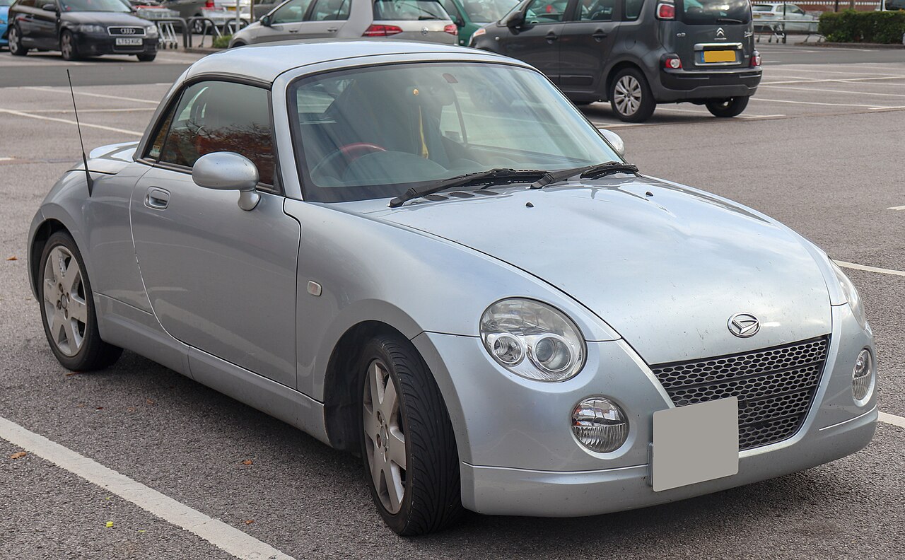 2007 Daihatsu Copen 1.3 in silver with its hard roof up, front three-quarter view in a car park.