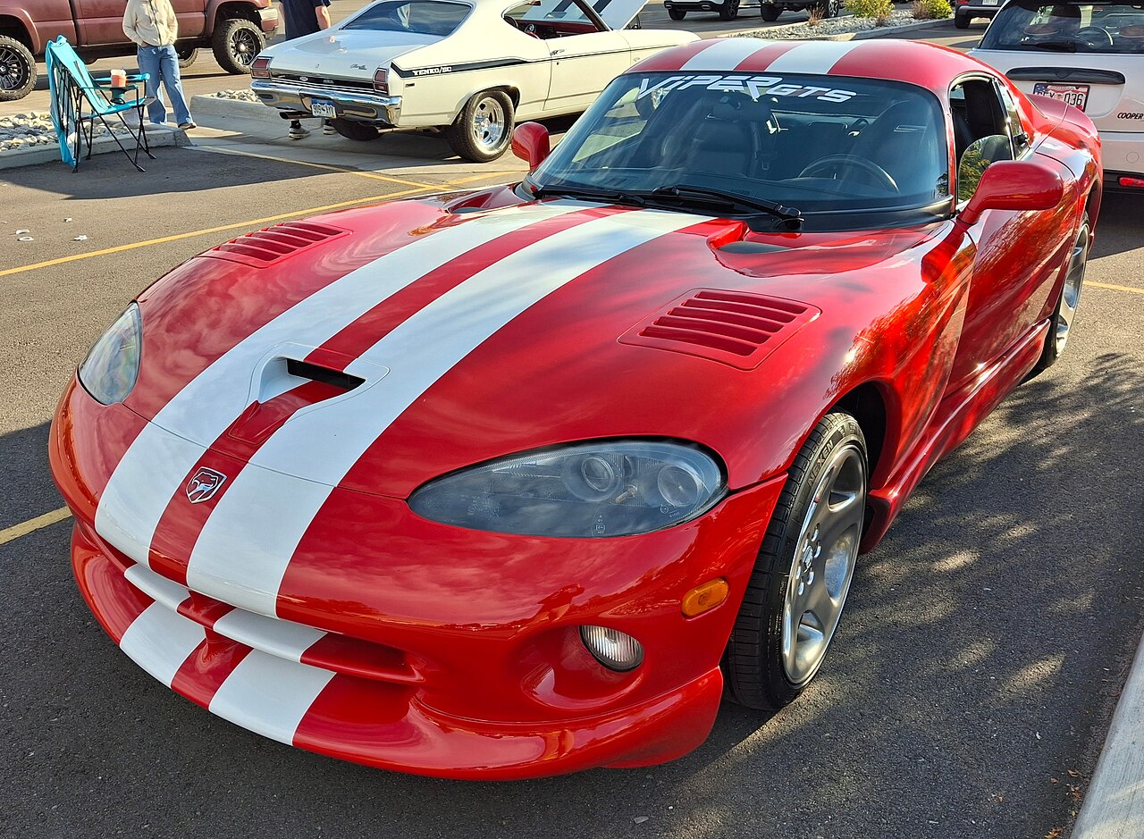 Red 2002 Dodge Viper GTS with white stripes, front three-quarter view in a car park at a cars-and-coffee meet.