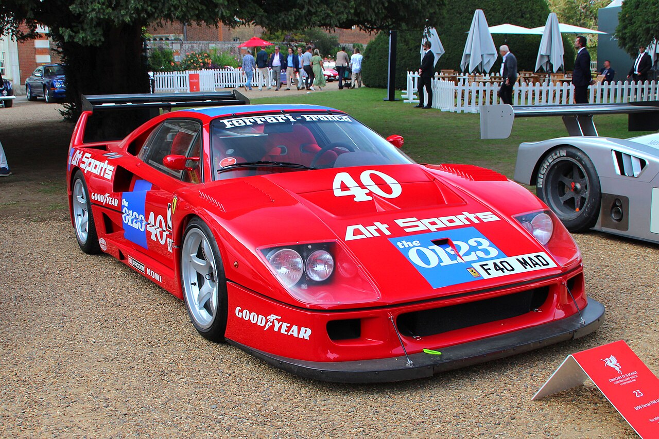 Red Ferrari F40 LM in Art Sports race livery with the number 40, front three-quarter view on a gravel path.