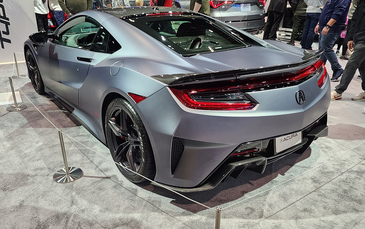 Matte grey Acura NSX Type S, rear three-quarter view behind a rope barrier at an auto show.