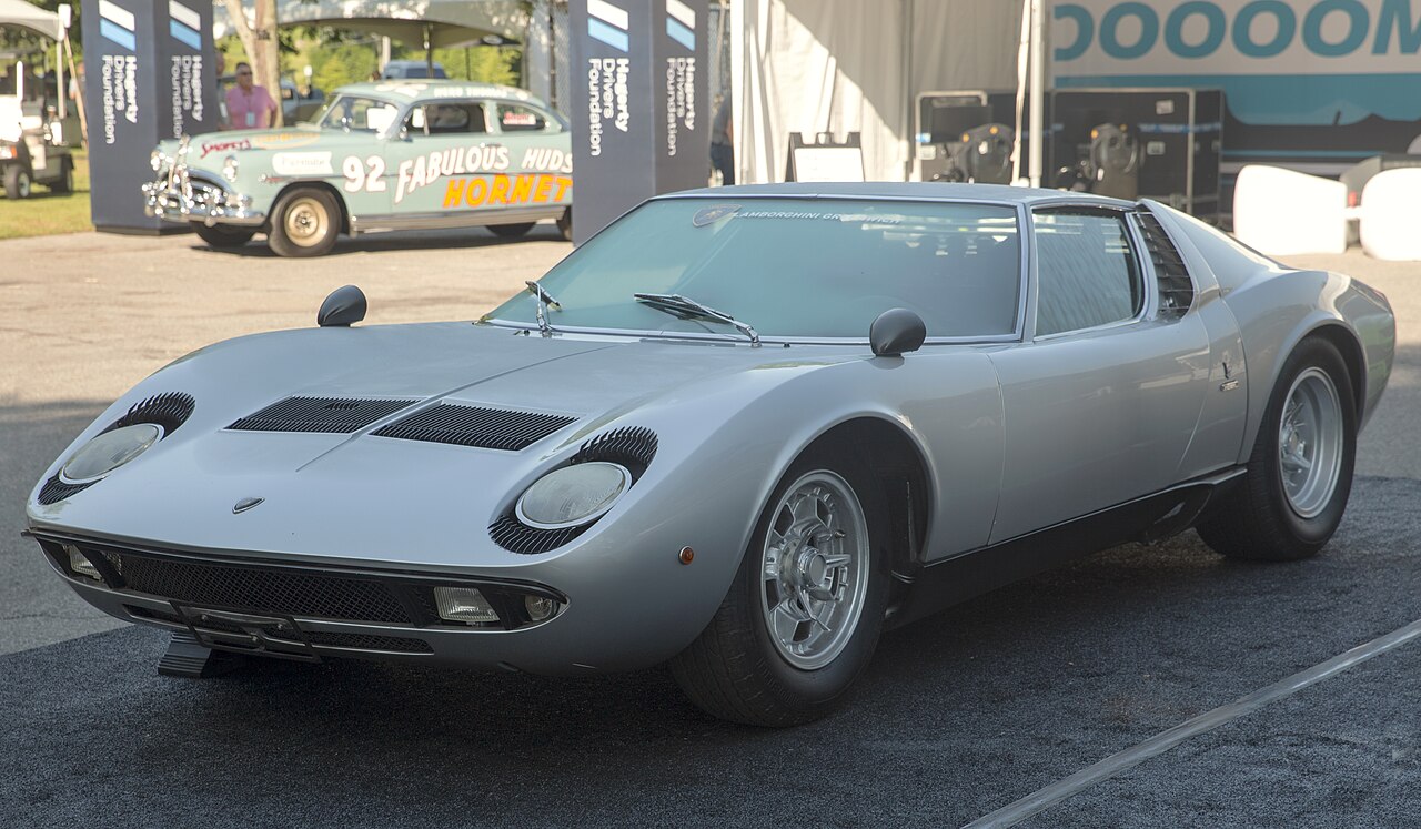 Silver 1969 Lamborghini Miura P400 S seen from the front left, parked outdoors at a car event.