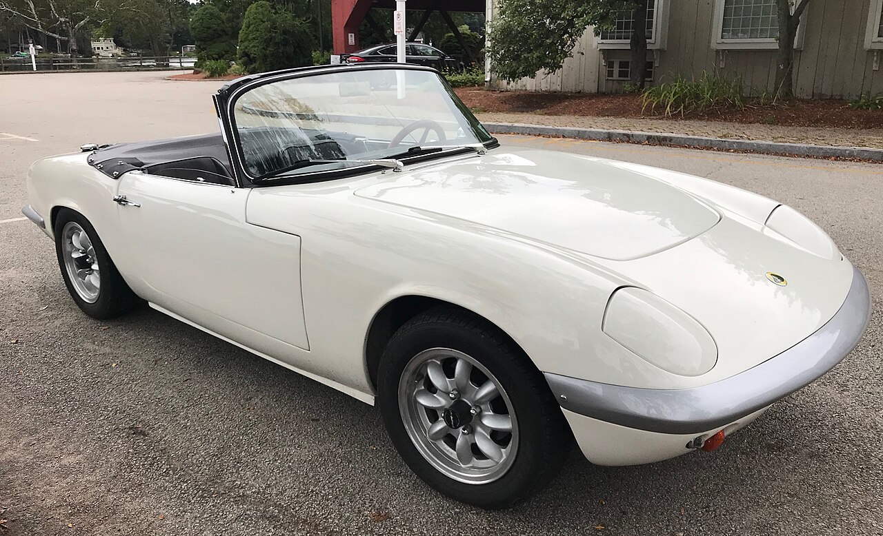 White Lotus Elan Series 2 roadster with its roof down and alloy wheels, front right three-quarter view in a car park.