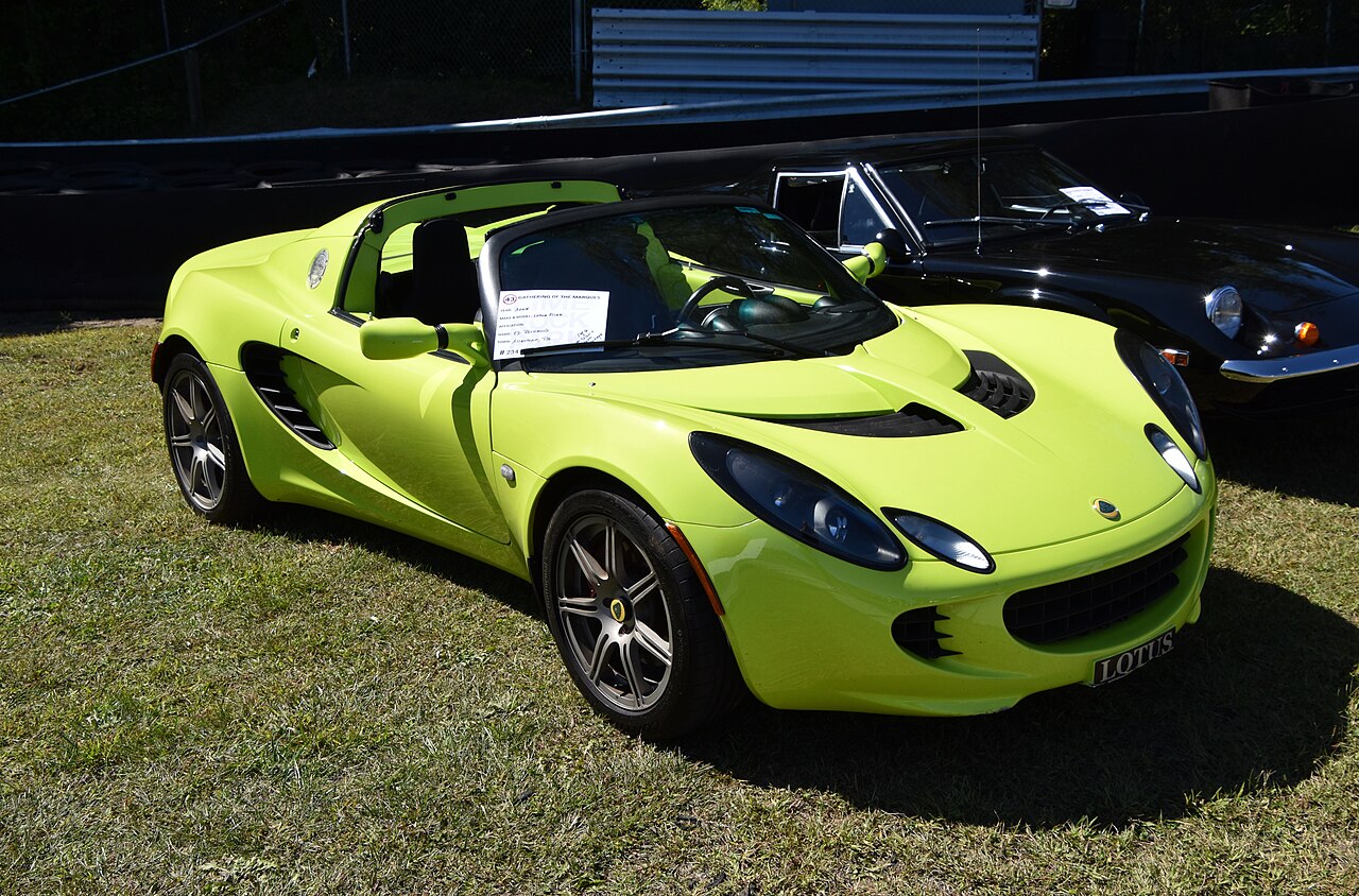 Lime green 2005 Lotus Elise with its roof off, front three-quarter view on grass at a car show.