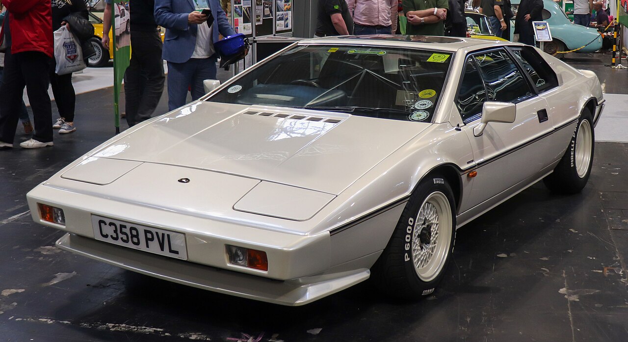Pearl white 1986 Lotus Esprit Series 3, front three-quarter view indoors at a car show.