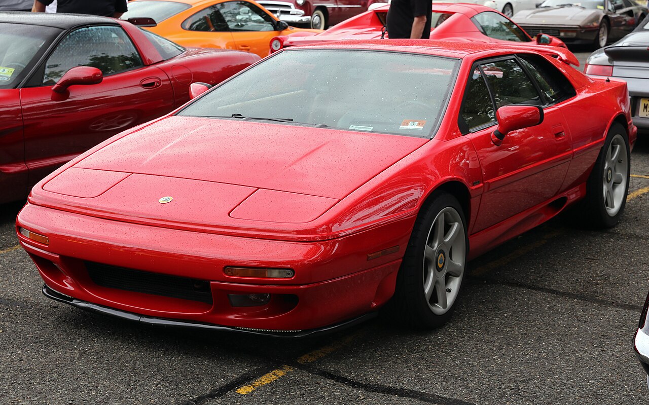 Red Lotus Esprit S4, front three-quarter view in a wet car park with raindrops on the paint.