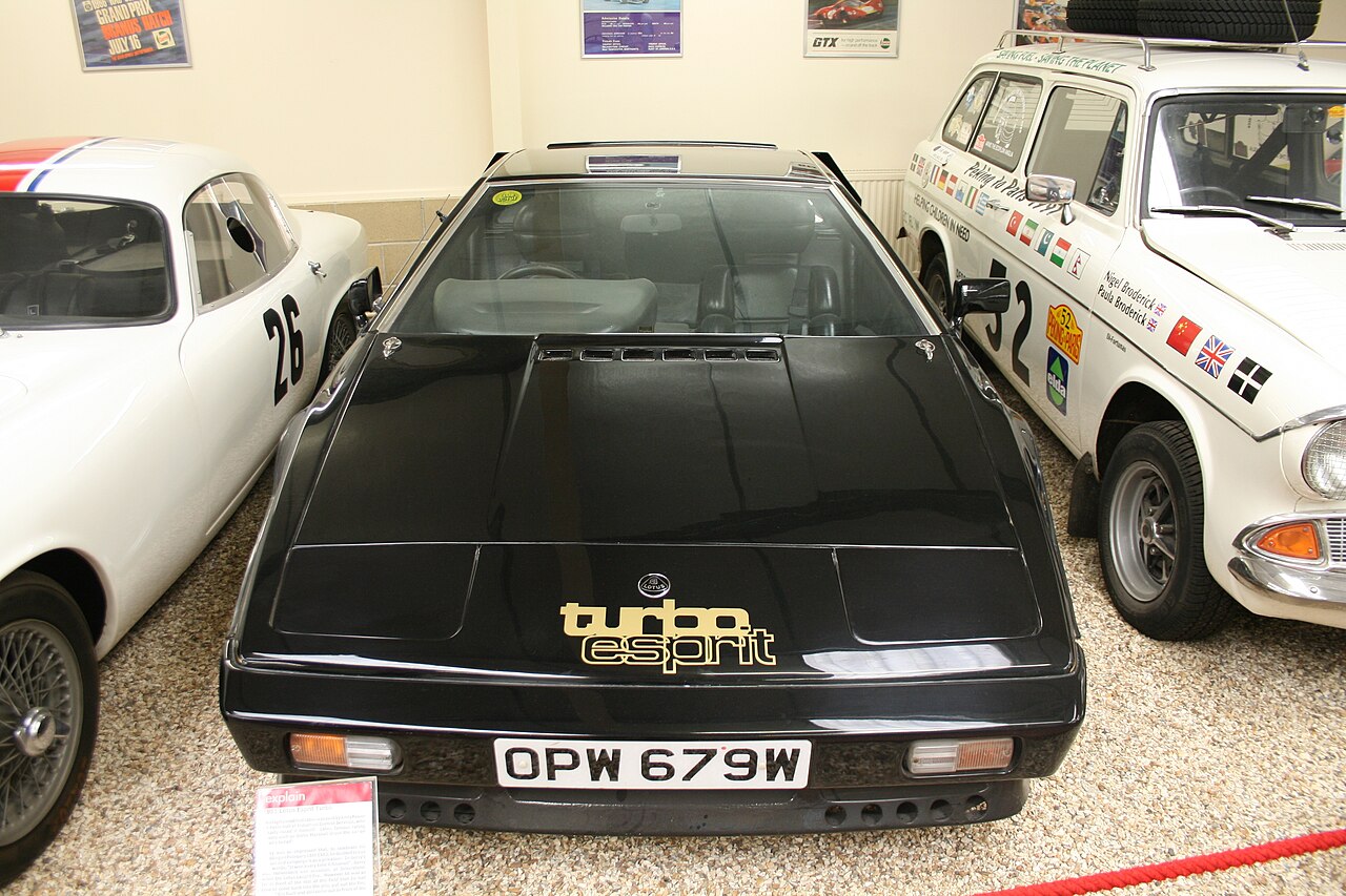 Black 1981 Lotus Esprit Turbo with gold Turbo Esprit lettering on its nose, seen head-on in a motor museum.