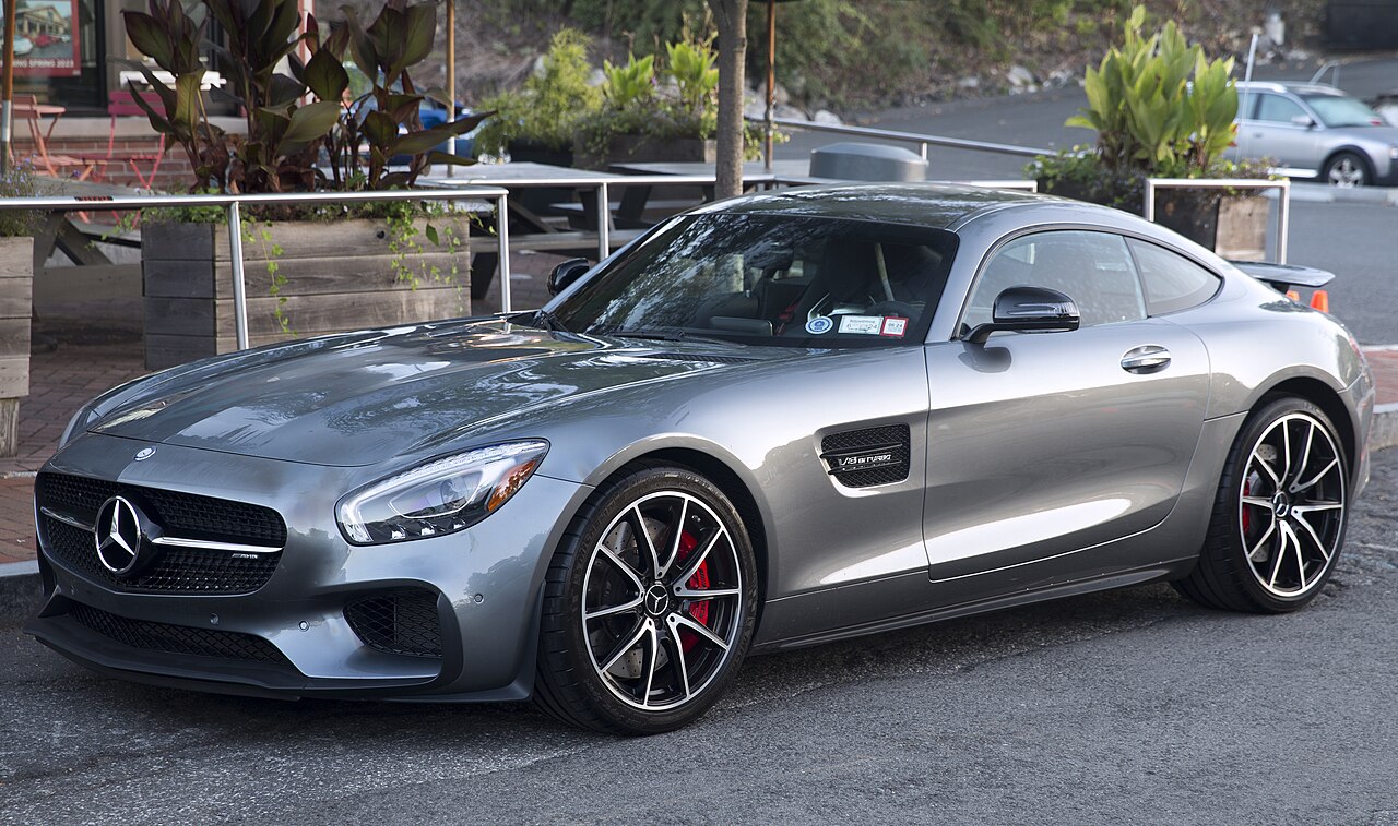Grey 2016 Mercedes-AMG GT S Edition 1 coupe, front left three-quarter view parked on a street beside planters.