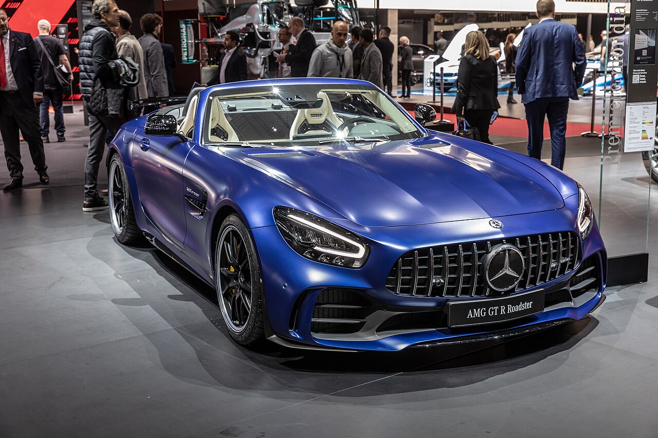 Blue Mercedes-AMG GT R Roadster with its roof down, front right three-quarter view on a stand at the 2019 Geneva Motor Show.