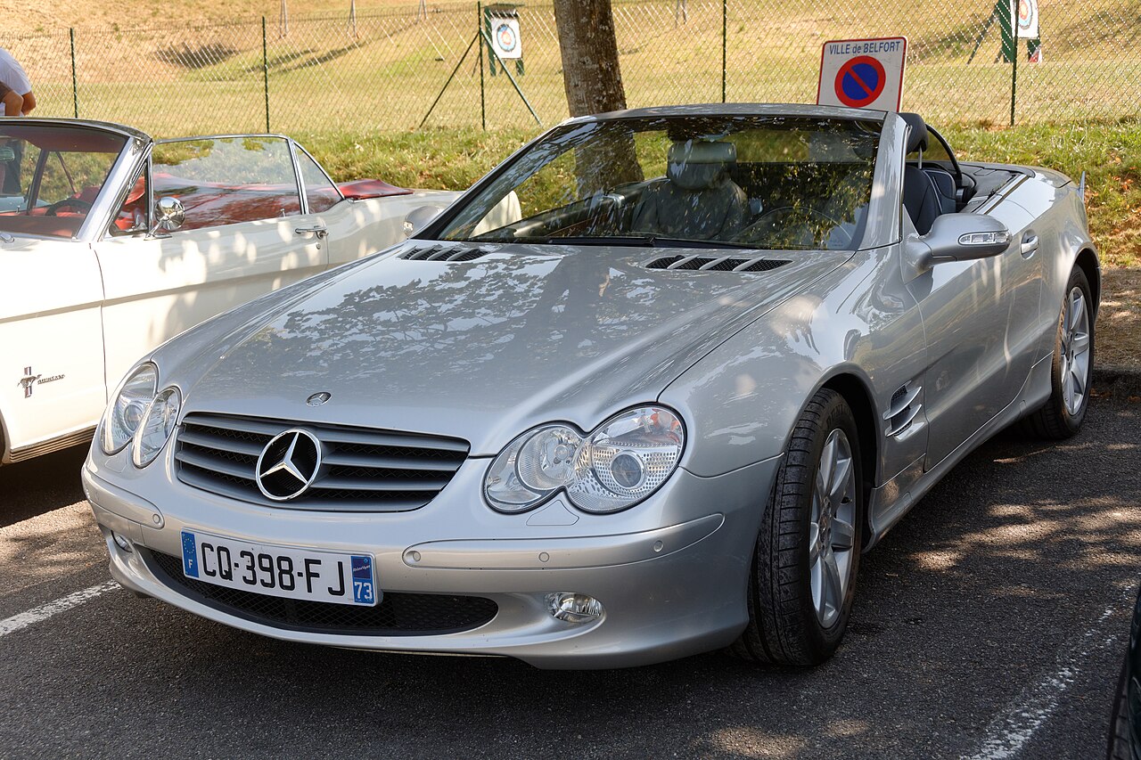 Silver Mercedes-Benz SL (R230) with its roof down, front three-quarter view in a car park at a convertible show.