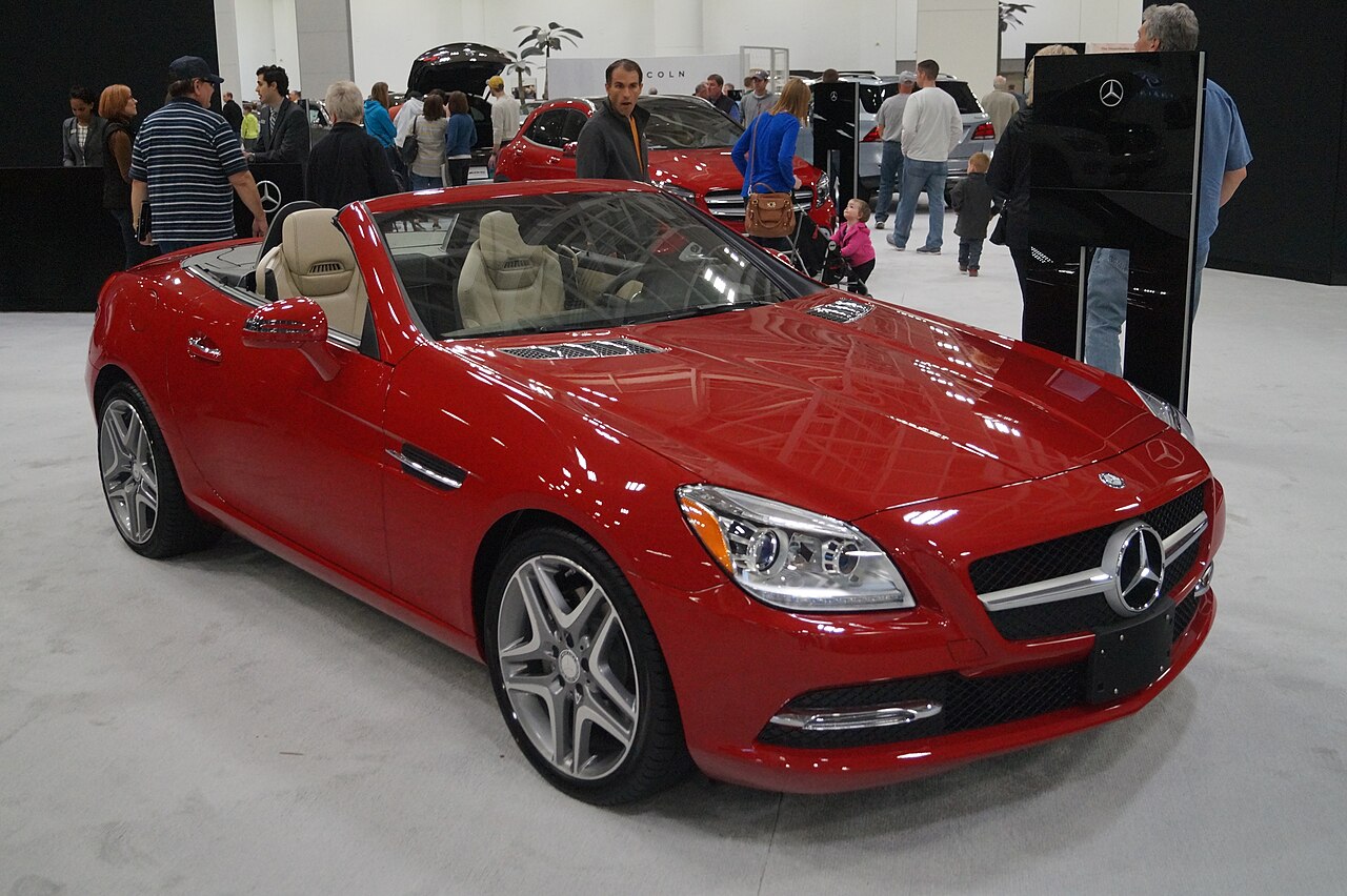 Red Mercedes-Benz SLK roadster with its roof down, front right three-quarter view at the 2016 Twin Cities Auto Show.