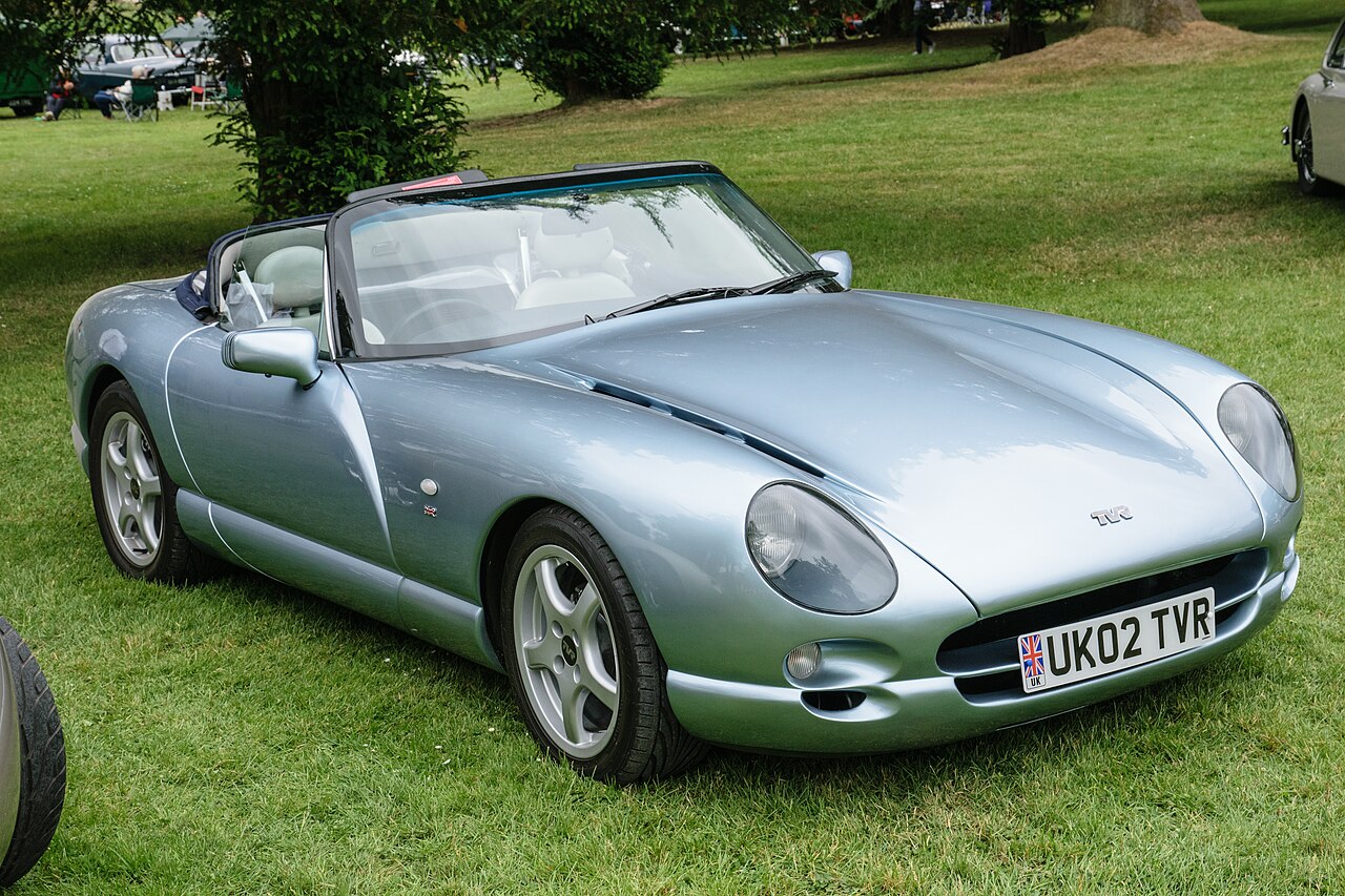2002 TVR Chimaera in silver-blue with its roof down, front right three-quarter view on grass at a classic car show.